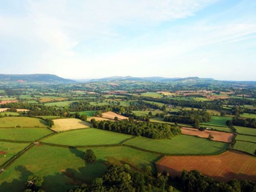 Golygfa o'r awyr o dirwedd canol Sir Fynwy, yn edrych tuag at Fannau Brycheiniog